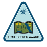 Trail map with trees, cabins, bodies of water, and dashed lines to symbolize trails.